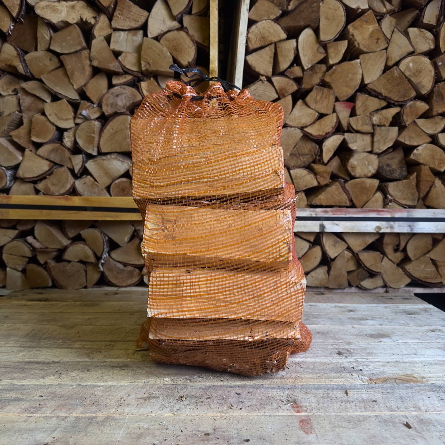 Stack of firewood with a background of stacked logs