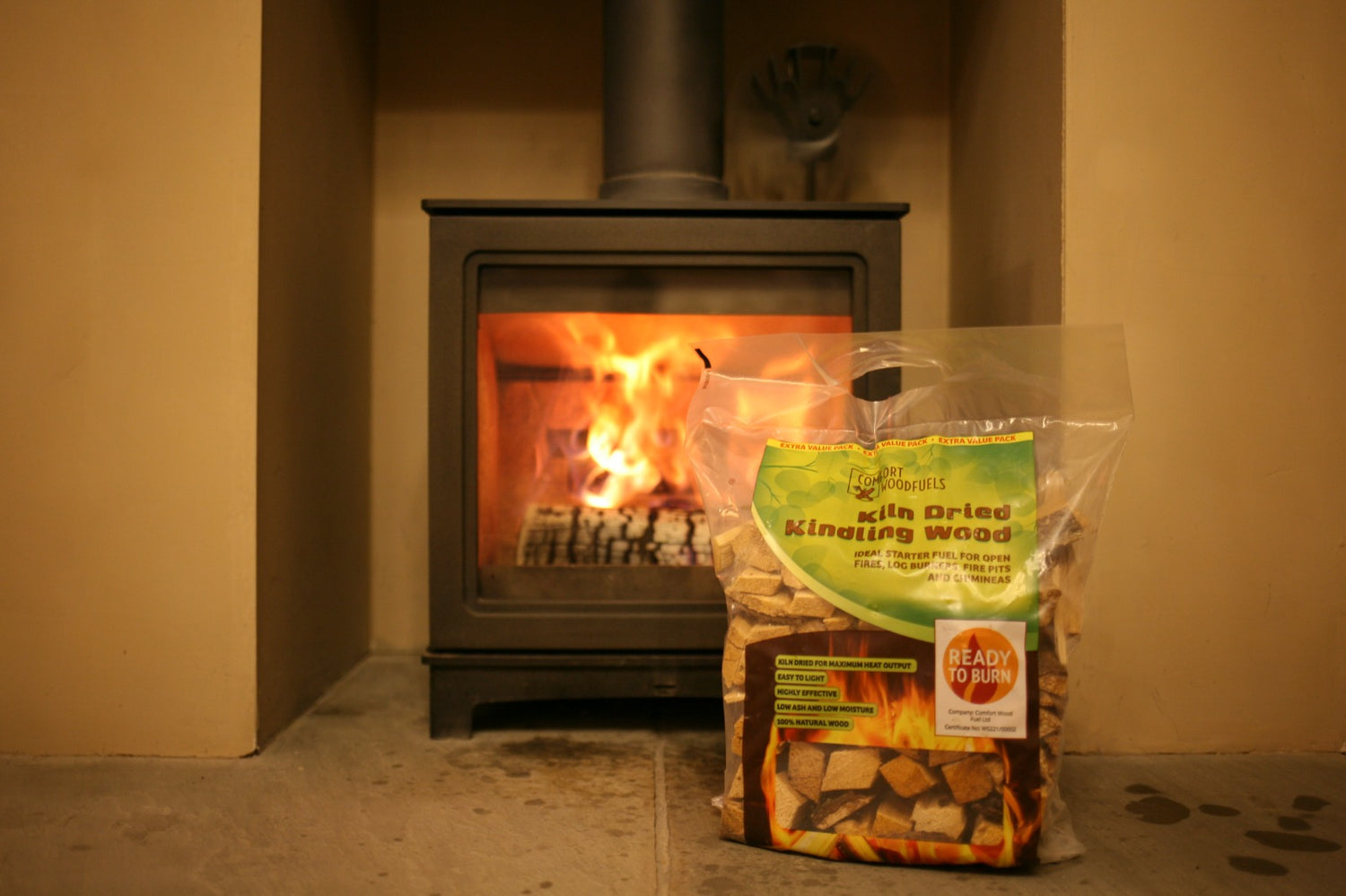 Mortimers Fuels kindling carry bag in front of a lit fireplace, perfect for log fires in Leyland homes.